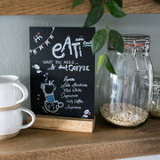 Kreidetafel mit Holzfuß als Tischaufsteller von HMF DIN A6 Hochformat in Schwarz im Regal zwischen Gläser und Tassen
